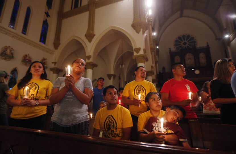 Worshipers participate in a "United To Heal Prayer Vigil" at Cathedral Guadalupe in Dallas on Friday, in honor of the police officers who were slain on Thursday. Gerald Herbert/AP