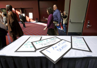 Attendees walk past a handful of placards during a break in the Methodists annual conference in Portland, Ore., in May 2016. The United Methodist Church, the nation's largest mainline Protestant denomination, was holding its once-every-four-years meeting and is facing a bitter fight over whether it should lift the church ban on same-sex marriage. Don Ryan/AP