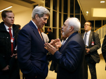 Secretary of State John Kerry talks with Iranian Foreign Minister Mohammad Javad Zarif in Vienna on Jan. 16, after the International Atomic Energy Agency verified that Iran met all conditions under the nuclear deal. The accord is now one-year-old. Iran is seen as abiding by the requirements of the deal, but its relations with the U.S. and other rivals have not improved on other fronts. (Photo by Kevin Lamarque/AP)