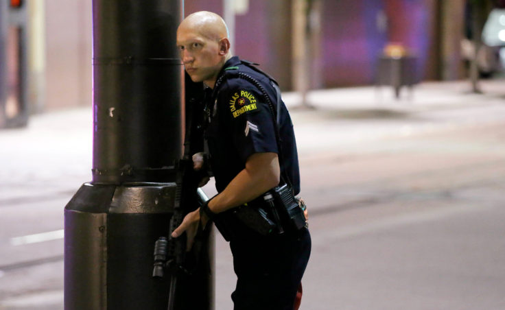 A Dallas policeman keeps watch on a street in downtown Dallas on Thursday.