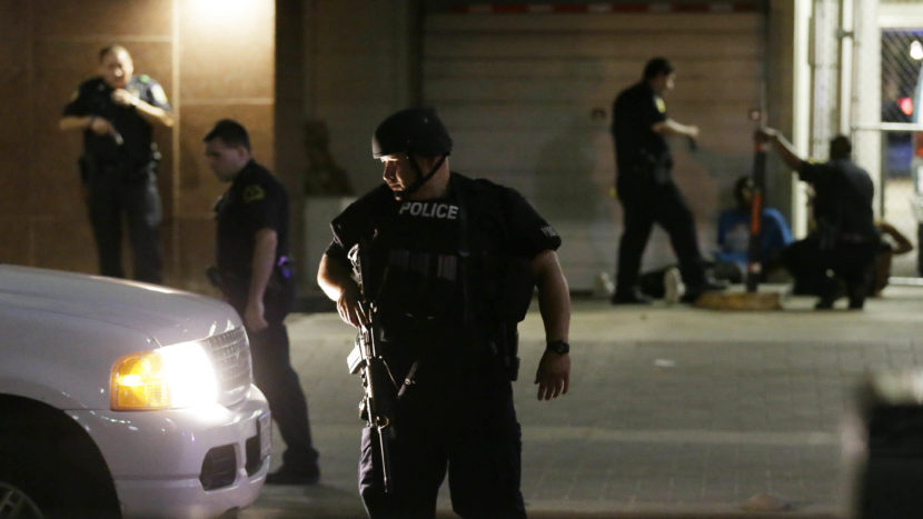 Dallas police detain a driver after several police officers were shot Thursday evening in downtown Dallas. Snipers shot police officers — killing several — during a peaceful protest, the city's police chief said at a news conference. (Photo by L.M. Otero/AP)