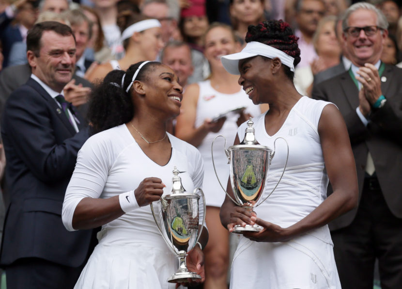 Serena Williams, left, and Venus Williams hold their trophies after winning the women's doubles final against Yaroslava Shvedova of Kazahkstan and Timea Babos of Hungary on day 13 of the Wimbledon Tennis Championships in London on Saturday. Tim Ireland/AP