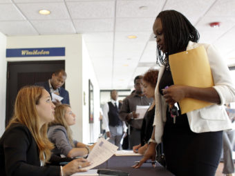 Claudia Caballero, a district manager for Aldi, talks with applicant Manoushka Metellus (right) at a job fair in Florida earlier this month. With a low unemployment rate, consumers are still spending but business inventories fell during the second quarter. Lynne Sladky/AP