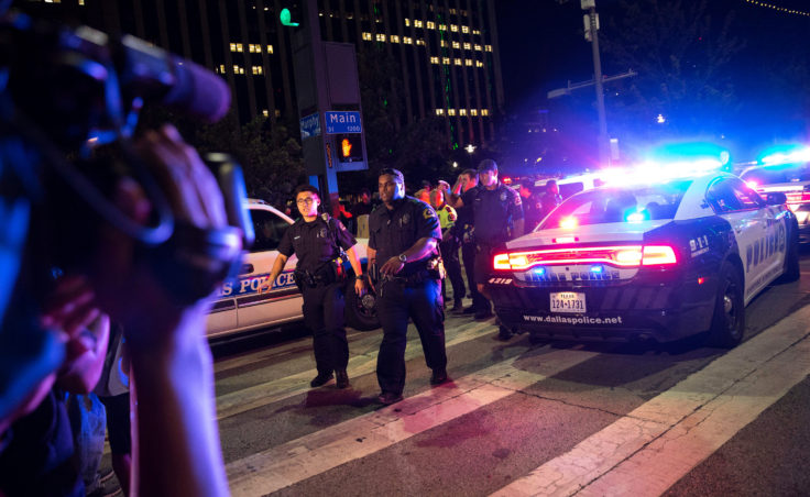 Bystanders stand near police barricades following the sniper shooting in Dallas on Thursday. (Laura Buckman/AFP/Getty Images)