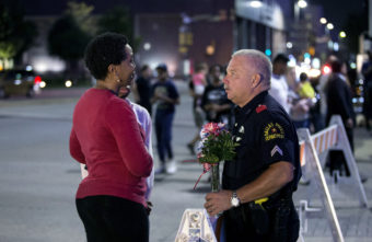 A woman speaks with an officer atÂ a vigil outside Dallas police headquarters in Dallas on Friday. Bilgin Sasmaz/Anadolu Agency via Getty Images