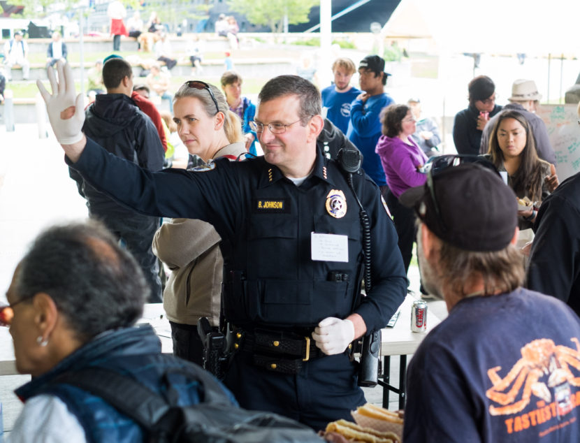 Juneau Chief of Police Bryce Johnson waves at a community barbecue held in Marine Park to "be counted as a person against violence, against discrimination, and against hate," according to the Juneau Police Department Facebook page, July 20, 2016. (Photo by Annie Bartholomew/KTOO)