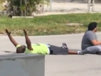 In a video filmed on Monday, Charles Kinsey (left) lies next to the autistic patient he was trying to help, holding his hands up in an effort to assure the North Miami police that they aren't a threat. Kinsey was later shot in the leg by the police. (Photo by Channel 7 WSVN/Screenshot by NPR)