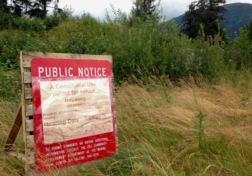 A sign advertising a public meeting marks the location of a planned senior housing building at Vintage Park in the Mendenhall Valley . (Photo by Ed Schoenfeld/CoastAlaska News)