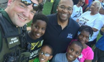A Wichita police officer poses with residents at the First Steps Community Cookout on Sunday. (Photo courtesy Wichita Police)