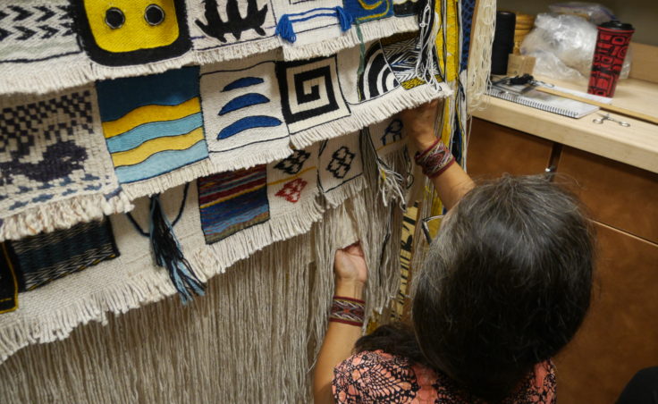 Clarissa Rizal unpins a block to show the details in the weave. (Photo by Tripp J Crouse/KTOO)