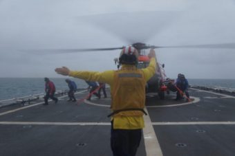 A member of the Stratton’s crew signals to the pilot of a Coast Guard helicopter during a training exercise held earlier this month off Alaska’s northern coast. The agency has stationed two MH-60 helicopters in Kotzebue to help it respond more quickly to emergencies around the remote Arctic expanse. (Photo by Gina Caylor, U.S. Coast Guard)