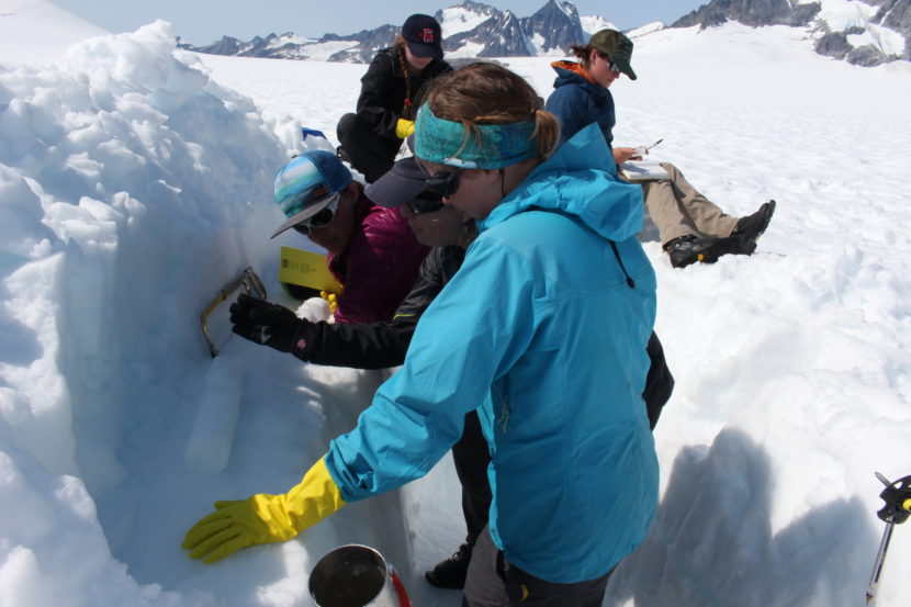 Natalie Kehrwald leads a group of Juneau Icefield Program students on how to saw an ice core. (Photo by Elizabeth Jenkins/KTOO)