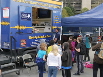 A young crowd gathers around the earthquake simulator on Wednesday, August 31, 2016. The emergency preparedness and awareness event was hosted by Alaska Division of Homeland Security and Emergency Management and Juneau Local Emergency Planning Committee. (Photo by Tripp J Crouse/KTOO)