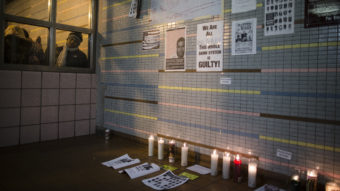 A demonstrator peers at a memorial to Akai Gurley at a public housing complex in Brooklyn, N.Y. Gurley was shot and killed by an NYPD officer in November 2014. (John Minchillo, Associated Press)