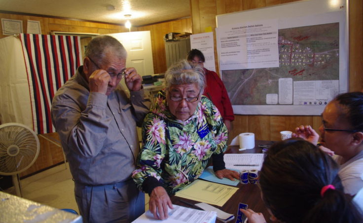 Anecia Toyukak helps her husband, Mike, look at the ballots in Manokotak on Aug. 16, 2016. (Photo by Molly Dischner/KDLG)