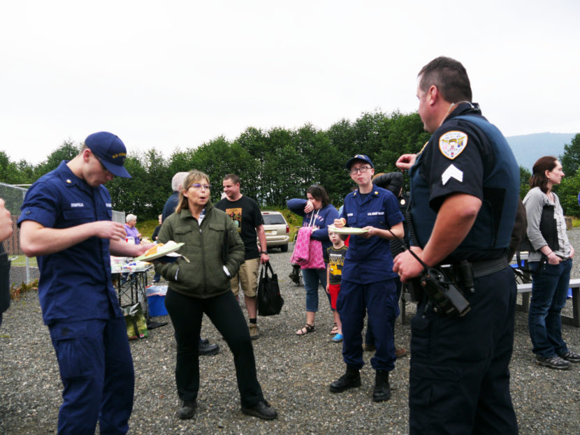 Juneau Police Department Sgt. Chris Gifford speaks with a two Coast Guard members and a community member during National Night Out, Aug. 2, 2016. (Photo by Lakeidra Chavis/ KTOO)