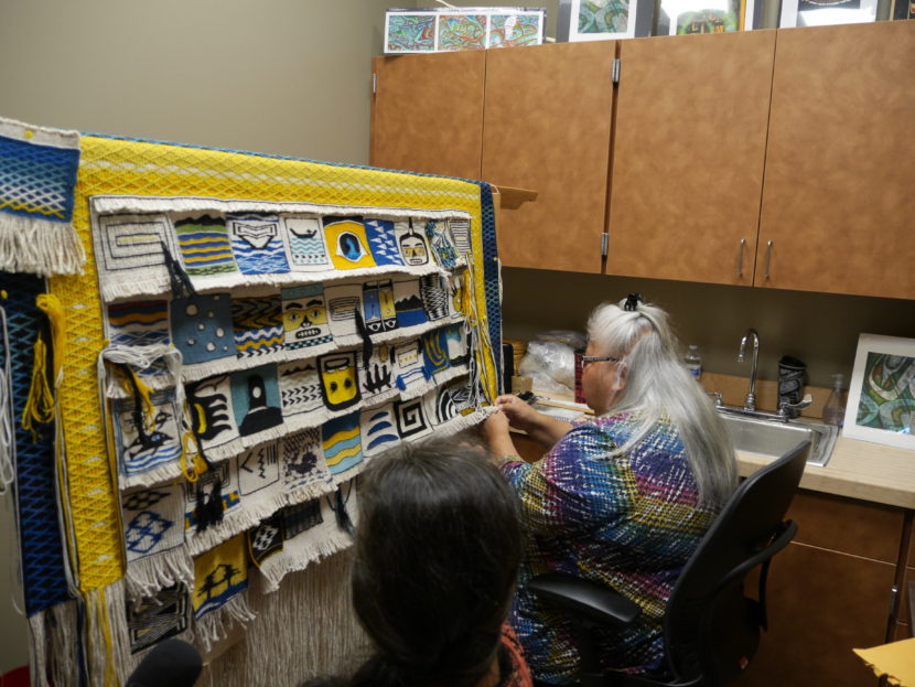 Clarissa Rizal and Della Cheney work on the robe in the Delores Churchill Artist in Residence space at the Walter Soboleff Center. (Photo by Tripp J Crouse/KTOO)