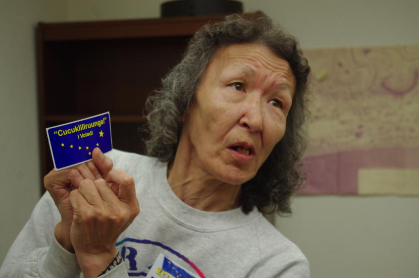 Sally Williams uses a sticker that says cucuklillruunga, or "I voted" in Yup'ik to teach the phrase at the Togiak voting site on Aug. 16, 2016. (Photo by Molly Dischner/KDLG)