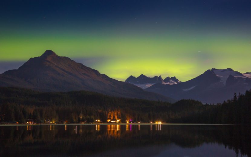 The aurora casts an eerie green light behind the mountains over Juneau on late Wednesday. (Photo by Matt Knutson)