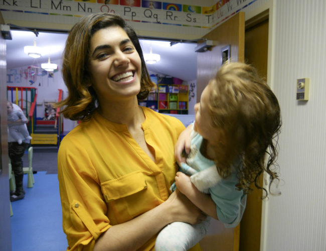 Issy Kako-Gehring holds her two-year-old daughter x. Issy runs the Gehring Nursery School in Juneau. (Photo by Lakeidra Chavis/ KTOO)