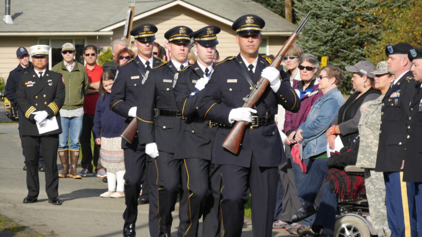 Juneau Police Department Honor Guard marches to the memorial flag staff on Sunday.