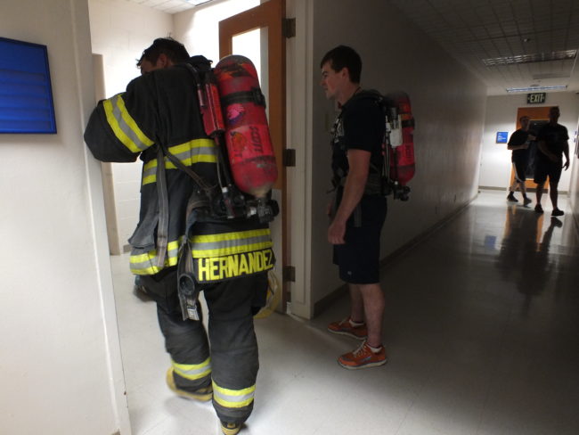 Firefighters rest while waiting for the freight elevator on the ninth floor of the federal building.