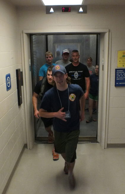 Firefighters and other participants in the stair climb emerge from a freight elevator in the basement of the federal building before ascending the stairs again. A few chose to run up all 110 stories.