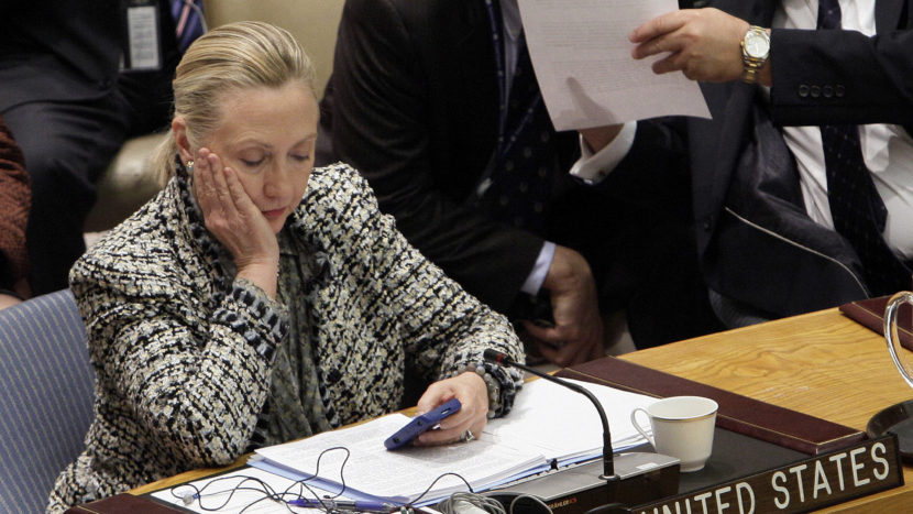 Hillary Clinton checks her phone after addressing the Security Council at the United Nations as secretary of state in 2012. (Photo by Richard Drew/AP)