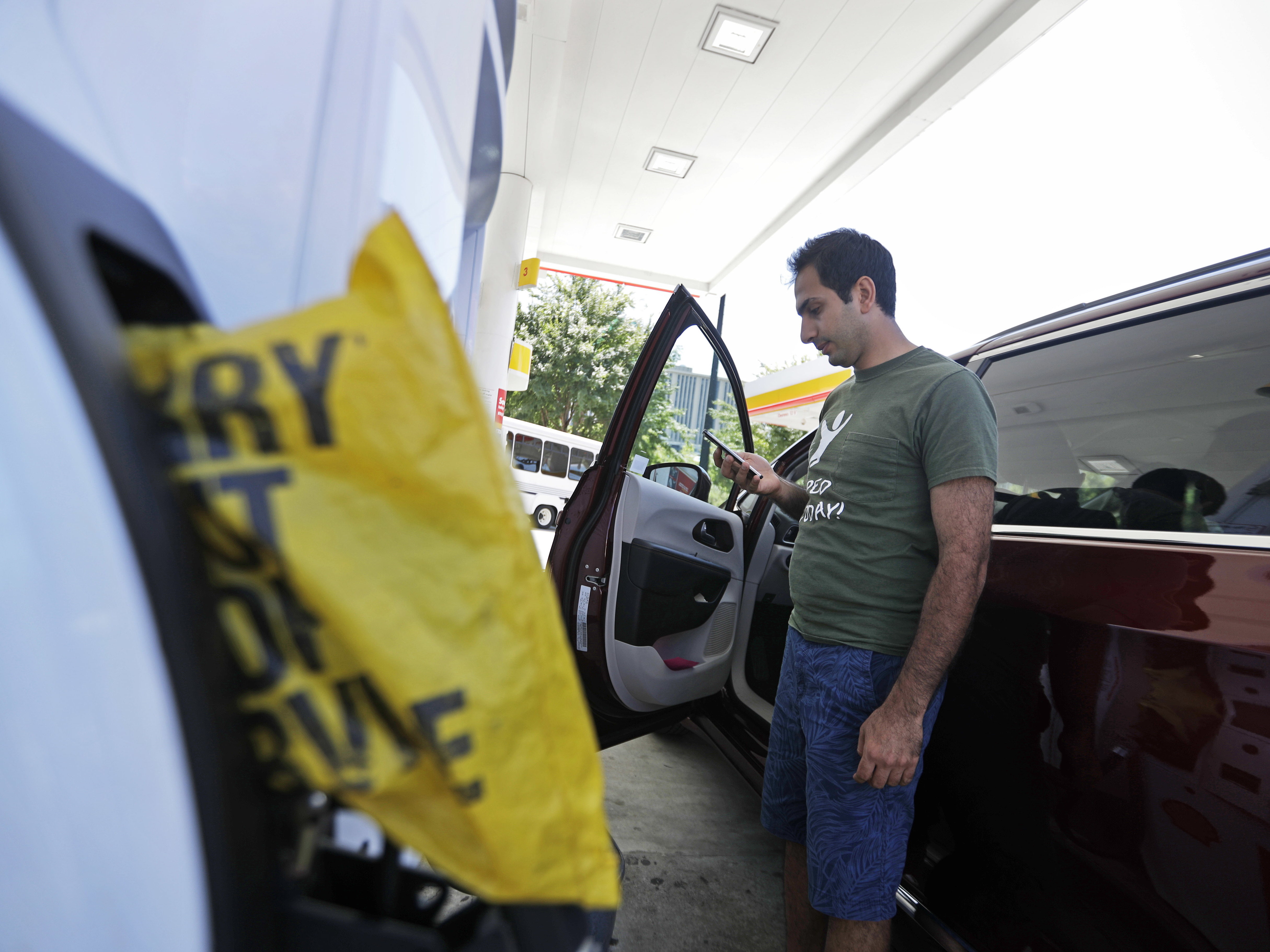 A motorist who found an Atlanta gas station had run out of fuel calls a nearby gas station Monday to see if they have any left. Gas prices spiked and drivers found "out of service" bags covering pumps as the gas shortage in the South rolled into the work week, raising fears that the disruptions could become more widespread. (Photo by David Goldman/Associated Press)