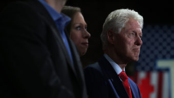 Former president Bill Clinton and his daughter, Chelsea Clinton, watch Hillary Clinton speak during a primary election night gathering April 19 in New York City. (Photo by Justin Sullivan/Getty Images)
