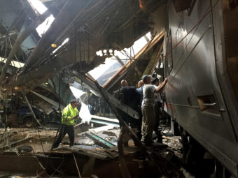 Train personnel survey the New Jersey Transit train that crashed into the platform at Hoboken Terminal on Thursday. (Photo by Pancho Bernasconi/Getty Images)