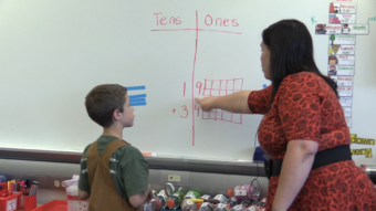 Eli Wyatt and Tia Vreeland work a math problem on the board.