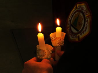 Candles are lit as Juneau firefighters read the names of other firefighters who died last year.