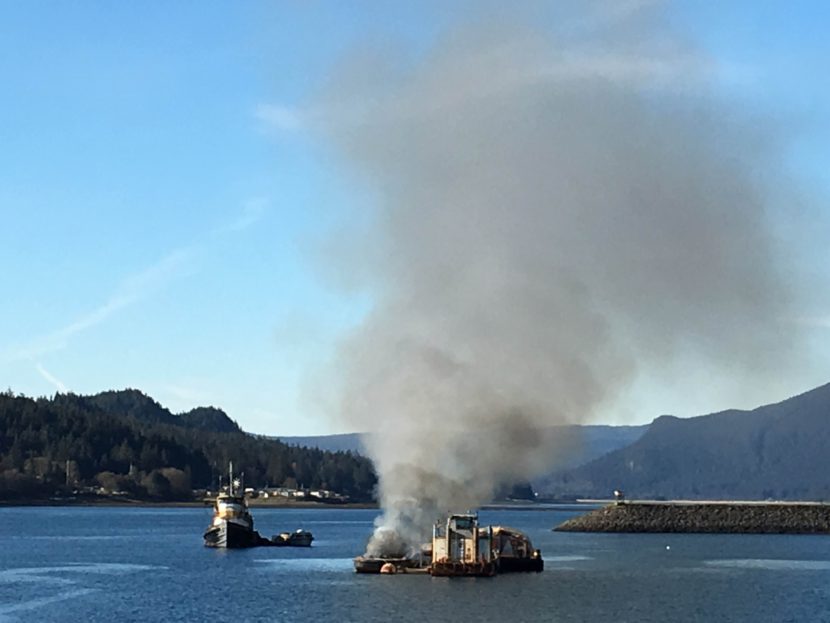 A small barge burns near Aurora Harbor along Egan Drive. (Lakeidra Chavis/ KTOO)