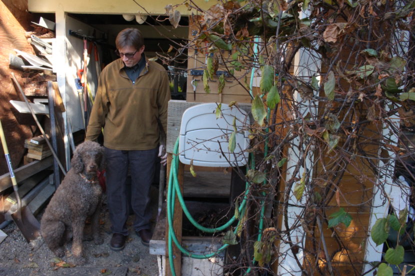 Bob Deering at his home with his dog Gamby and compost bins. (Photo by Elizabeth Jenkins/KTOO) 