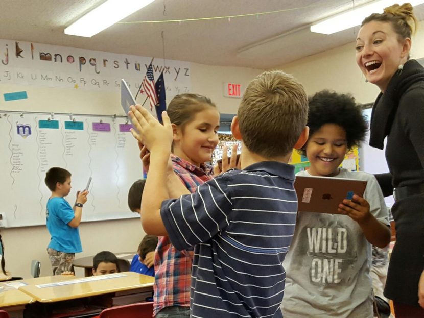 Students at Port Graham School test out their new iPads with teacher Devin Michel-Way. (Photo by Shahla Farzan/KBBI)