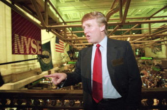 Real estate magnate Donald Trump stands above the New York Stock Exchange after taking his flagship Trump Plaza Casino public in New York City. Trump's business losses in 1995 were so large that they could have allowed him to avoid paying federal income taxes for as many as 18 years, according to records obtained by The New York Times. Kathy Willens/AP