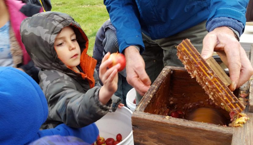 Neil Wagner helps local kids grind up apples to make apple juice.