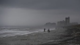 People bike on the beach ahead of Hurricane Matthew in Atlantic Beach, Fla., on Wednesday. Droves of people in the U.S. have begun evacuating coastal areas ahead of the storm, which tracked a deadly path through the Caribbean in a maelstrom of wind, mud and water. (Photo by Jewel Samad/AFP/Getty Images)