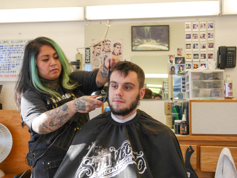 Eva Carrillo cuts Kyle White's hair at Gerry's Barbershop. Kyle has been going to the shop since he was a kid. 