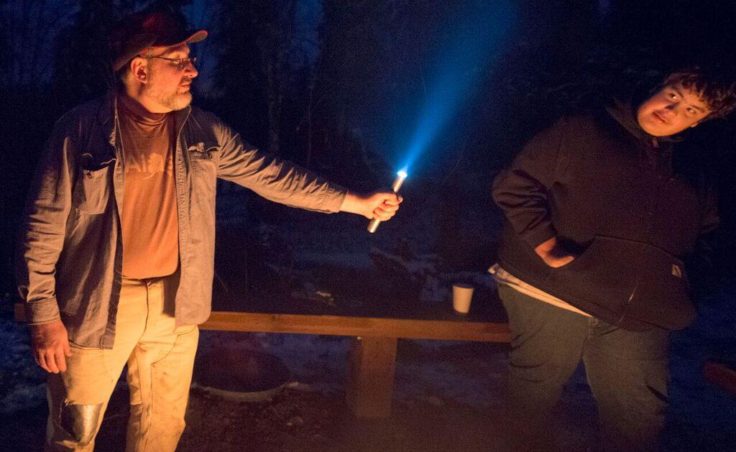 With a flashlight and a little smoke from a campfire, Youth Advocate Doug Gates creates a Star Wars light saber for Josh Grosvold and other campers in October 2016. (Photo by Scott Moon/Kenaitze Indian Tribe)