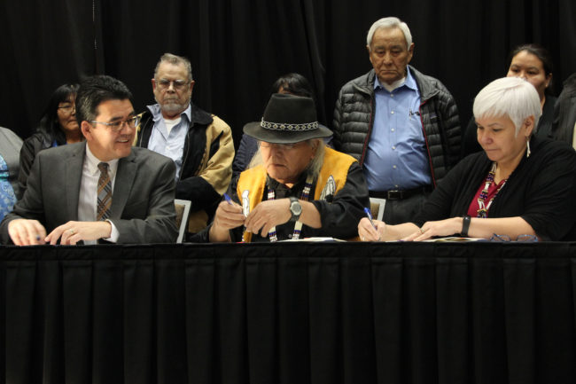 Deouty Interior Secretary Michael L. Connor joins Christopher Gene (center) and Karen Linnell of the Ahtna Intertribal Resource Commission to sign an agreement giving Alaska Native tribes in the Ahtna region more say over subsistence resources. (Photo by Rachel Waldholz/Alaska's Energy Desk)