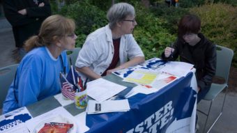 Volunteers help someone register to vote at the Governor's Picnic at the University of Alaska Southeast, Aug. 14, 2015. (Photo by Jeremy Hsieh/KTOO)