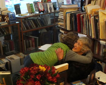 A long-time friend and customer greets Dee Longenbaugh during her going out-of-business sale.