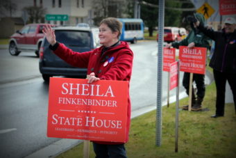 Republican candidate Sheila Finkenbinder waves to passing cars in Sitka on election day. (Photo by KCAW)