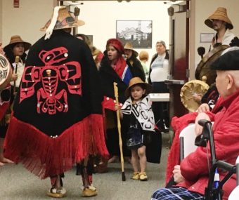 Kevin Clevenger displays his regalia as the New Path Dancers enter the Saxman Community Hall on Wednesday. (Photo by Leila Kheiry/KRBD)