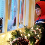 A young visitor watches a model train travel around its tracks in a winter display at the Alaska Governor Mansion annual holiday open house on Tuesday, Dec. 6, 2016 in Juneau. (Photo by Tripp J Crouse/KTOO)