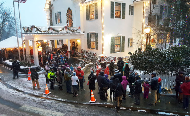 Several people wait in line for the Alaska Governor Mansion annual holiday open house on Tuesdsay, Dec. 6, 2016 in Juneau. Musical entertainment and heaters were available for people under the tent, while some volunteers passed out hot apple cider and treats to those waiting in the open. (Photo by Tripp J Crouse/KTOO)