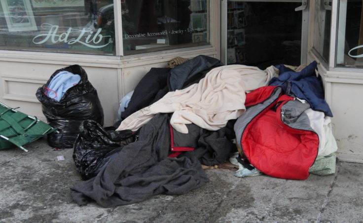 A pile of blankets in the doorway of a business on Franklin Street in downtown Juneau. (Photo by Quinton Chandler/KTOO)