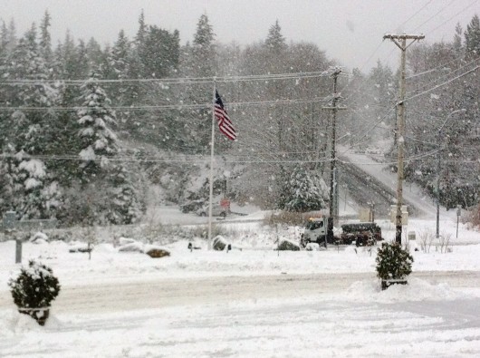 A city snow plow tries to keep up with the heavy snowfall in this photo from a few winters ago. (File photo by KRBD)